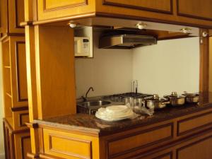cocina con fogones y algunas ollas y sartenes en Apartment on Oscar Freire by Paulista and Clínicas, en São Paulo