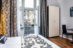 a bedroom with a bed and a window and a chair at Tribeca City Center Apartments in Krakow