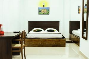 a bedroom with a bed with a desk and a desk at Thammenna Eco Cabins in Dambulla