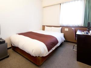
a hotel room with a bed and a desk at Hotel Abest Nagano Ekimae in Nagano
