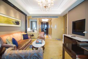 a living room with a couch and a tv at Wanda Vista Quanzhou in Quanzhou