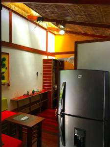 a kitchen with a refrigerator and a table in a room at Villa 3 - High End Studio Apartment with kitchen, Playa Chiquita in Cocles