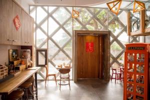a kitchen with a large window and a table with chairs at 墾丁橘月Orange Moon Inn in Kenting