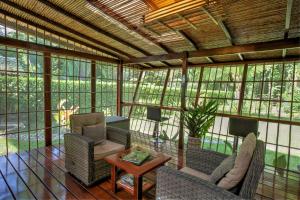 a screened in porch with chairs and a table at Zen Villa 1 - Three bedroom Luxury Villa with Private Garden, Playa Chiquita in Cocles +18 photos