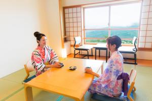two women sitting at a table in a room at Kyukamura Iwate-Amiharionsen in Shizukuishi