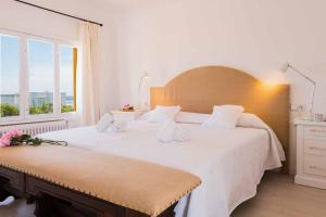 Un dormitorio con una gran cama blanca y una ventana en Villa Vica, en Santanyí