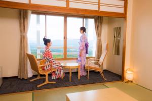 two women in kimonos looking out of a window at Kyukamura Iwate-Amiharionsen in Shizukuishi
