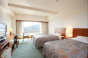 Habitación de hotel con 2 camas y ventana en Kyukamura Iwate-Amiharionsen, en Shizukuishi
