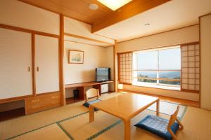 a living room with a table and a television at Kyukamura Iwate-Amiharionsen in Shizukuishi