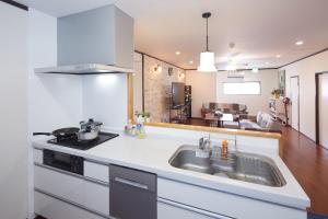a kitchen with a sink and a stove at Wind Makiminato in Makiminato