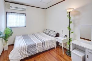 um quarto branco com uma cama e um lavatório em Wind Makiminato em Urazoe