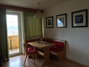 d'une salle à manger avec une table, des chaises et une fenêtre. dans l'établissement Schönhuberhof - Panoramalage, à Brunico