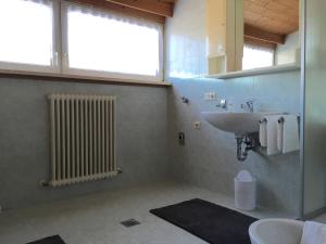 a bathroom with a sink and a toilet and a window at Schönhuberhof - Panoramalage in Brunico