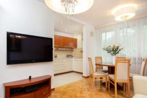 een keuken en eetkamer met een grote flatscreen-tv bij Two-Bedroom Family Apartment Esperanto next to Klif by Renters in Warschau