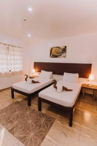 2 Betten im Wohnzimmer mit 2 Tischen in der Unterkunft Lavanya Beach And Dive Resort in Zamboanguita