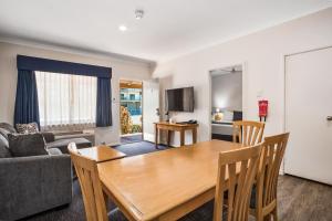 a living room with a table and a couch at Karratha Central Apartments in Karratha