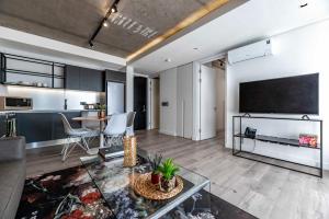 ein Wohnzimmer mit einem großen TV und einem Tisch in der Unterkunft 402 The Signature, De Waterkant in Kapstadt