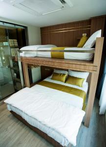 two bunk beds in a room with a mirror at GHEE GELATO HOUSE in Bangkok