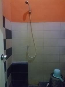 a shower with a hose in a bathroom at Cendrawasih Syariah Homestay in Lampung