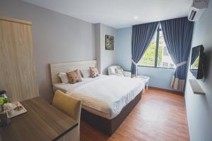 a bedroom with a bed and a large window at V3 Hotel & Residence Seri Alam in Pasir Gudang