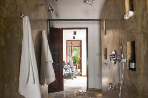 a bathroom with a shower and a door to a room at Why House in Unawatuna