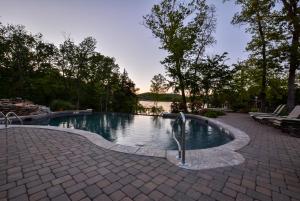 a swimming pool in the middle of a patio at Luxury Lakefront Chalet Resort 2 Pools FREE Amenities Dock MiniGolf Waterslide in Lampe