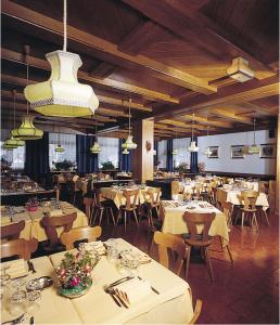 a restaurant with white tables and chairs and lights at Hotel Venezia in Rocca Pietore