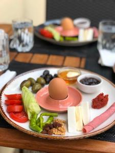 a plate with an egg and vegetables on a table at Queen Bee Hotel in Selcuk