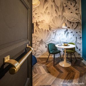 een tafel en stoelen in een kamer met een muur bij Le Hammam du Panier in Marseille