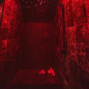 een rode badkamer met schoenen op de vloer van een douche bij Le Hammam du Panier in Marseille