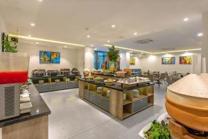 a restaurant with a buffet line with food on display at Hoi An Aurora Riverside Hotel and Spa in Hoi An