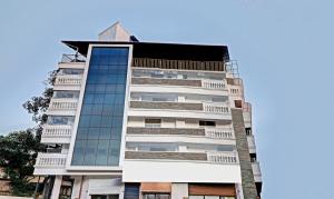 a tall white building with glass windows at Itsy By Treebo - Dew Dreams in Cochin