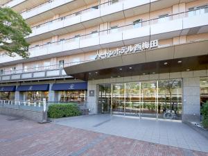an external view of a building with a large glass door at Hearton Hotel Nishi Umeda in Osaka
