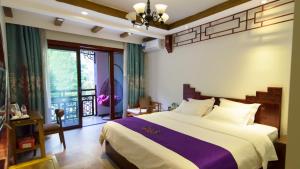 a bedroom with a large bed and a window at Fenghuang Tujia Ethnic Minority River View Hotel in Fenghuang County