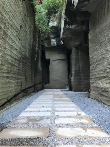 un callejón en un edificio antiguo con una pared de piedra en Honjin, en Izunokuni