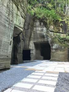 a cave in a rock wall with two tunnels at Honjin in Izunokuni