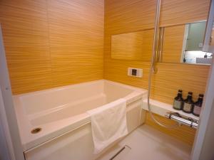 a bathroom with a bath tub and a shower at GRAND BASE Beppueki in Beppu