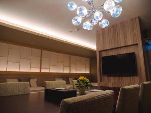 una sala da pranzo con tavolo e lampadario pendente di GRAND BASE Beppueki a Beppu