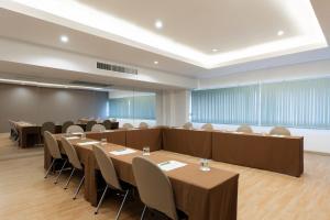 BU Place Hotel في بانكوك: قاعة اجتماعات فيها طاولات وكراسي
