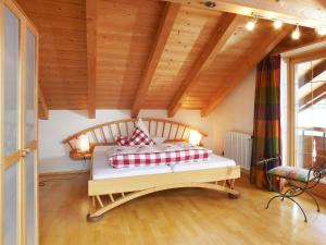 Schlafzimmer mit einem Bett mit roten und weißen Kissen in der Unterkunft Ferienwohnungen Schwendinger in Oberstdorf