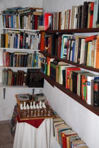 uma parede com prateleiras cheias de livros em L'Almàssera Casa Rural & Restaurant em Margarida