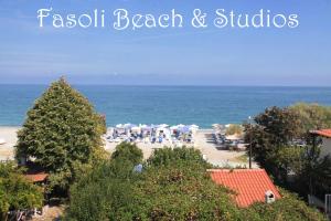 een uitzicht op een strand met parasols en de oceaan bij Fasoli Studios in Paralia Panteleimonos