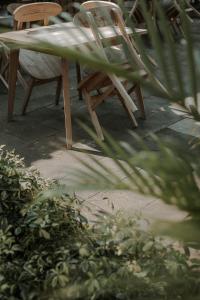 a wooden table and chairs and a plant at Keboen Ndalem Homestay in Semarang