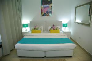 a bedroom with a large white bed with two lamps at Prime Hotel in Amman