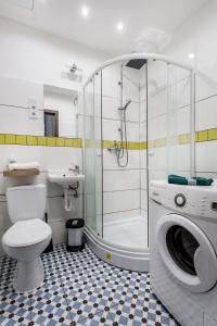 a bathroom with a shower toilet and a washing machine at Mickey's Chain Bridge Apartments in Budapest