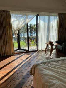 a bedroom with a bed and a view of the ocean at Coconut Beach Homestay in Beinan