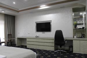 a hotel room with a television and a bed at Erebuni Hotel Yerevan in Yerevan