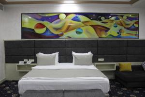 a hotel room with two beds and a painting on the wall at Erebuni Hotel Yerevan in Yerevan