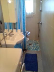a bathroom with a sink and a shower with a blue rug at condominio guanabara in Lido di Jesolo +12 photos