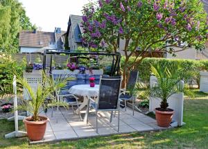 einen Tisch und Stühle in einem Garten mit Pflanzen in der Unterkunft Ferienwohnung zur Baaber Heide in Baabe